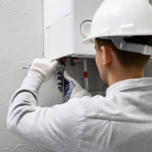 homme répare une pompe à chaleur